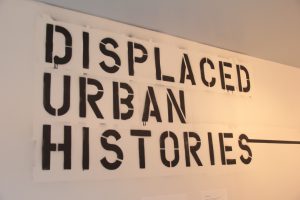 The words "Displaced Urban Histories" spray painted onto gallery wall