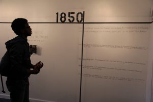 A visitor looks at the interactive timeline that begins at 1850
