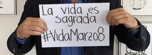Antanas Mockus holds sign saying "La vida es sagrada #VidaMarzo8"